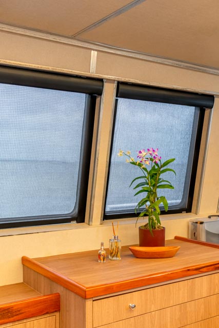 Cortinas para embarcação: como garantir conforto térmico, proteção solar e eficiência energética 1 Cortina Rolo KoolBlack® Hunter Douglas em cabine de embarcação, oferecendo controle solar e conforto térmico durante a navegação.